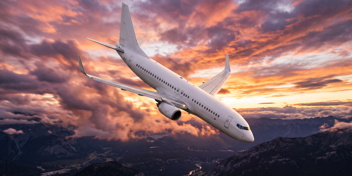 Avión comercial de pasajeros en descenso pronunciado en un cielo dramático al amanecer