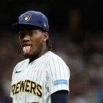 El lanzador Abner Uribe, con el uniforme número 45 de los Cerveceros de Milwaukee, saca la lengua en el terreno durante un partido