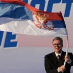 Serbia vota el domingo en una pugna entre Vučić y los estudiantes Aleksandar Vučić sonríe mientras ondea una bandera de Serbia frente a un cartel político