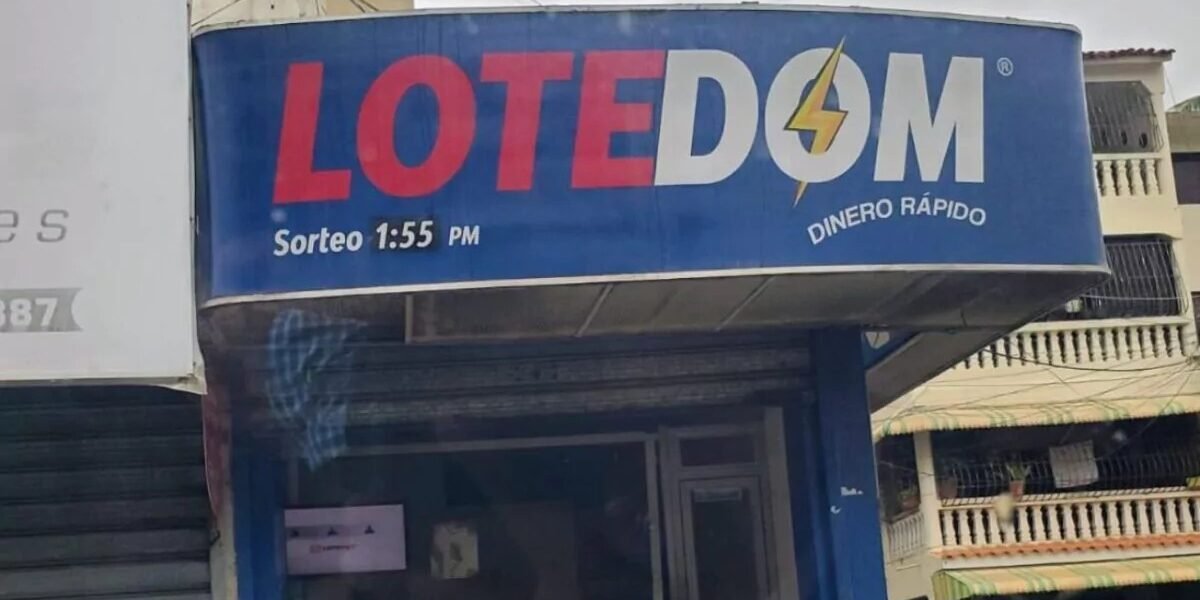 Fachada de una banca de lotería con un letrero azul y la puerta de vidrio cerrada en una calle