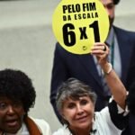 Mujeres sostienen carteles con el lema Pelo fim da escala 6x1 en Brasil