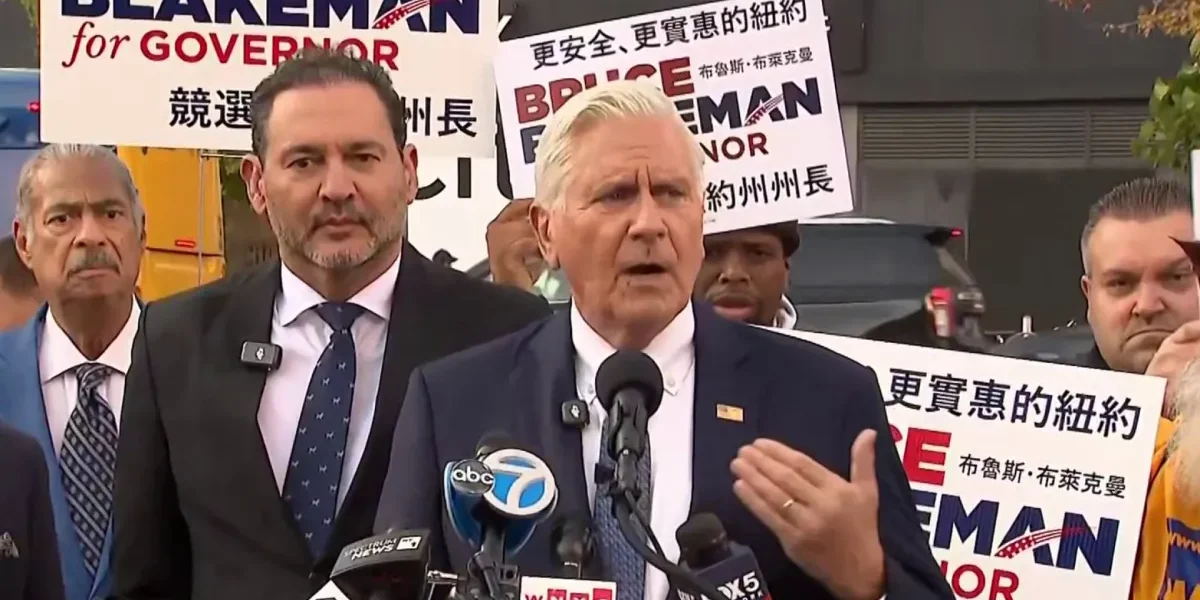 Bruce Blakeman habla ante micrófonos de varios medios, rodeado de simpatizantes con carteles de su candidatura a gobernador