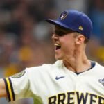 Un jugador de los Cerveceros de Milwaukee, con el parche de la Serie Mundial, grita y levanta el puño