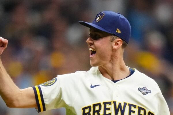 Un jugador de los Cerveceros de Milwaukee, con el parche de la Serie Mundial, grita y levanta el puño