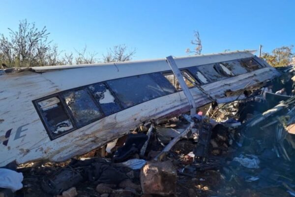 Un vagón de alta velocidad de Renfe, destrozado y volcado, con las ventanas rotas y restos metálicos esparcidos alrededor.
