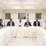 Legisladores reunidos alrededor de una mesa en forma de U durante una sesión de trabajo
