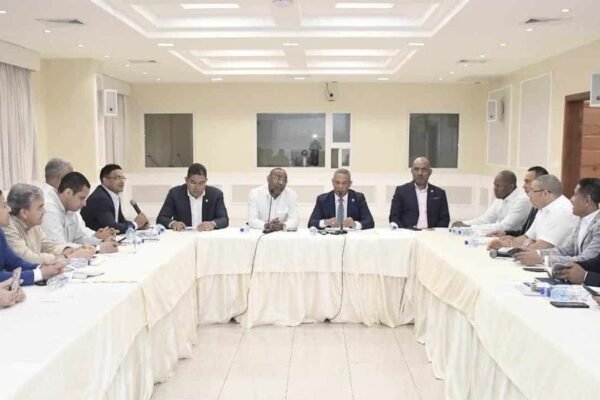 Legisladores reunidos alrededor de una mesa en forma de U durante una sesión de trabajo