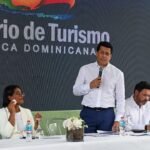 Turismo entrega obras de más de RD$25.5 millones en la Basílica de Higüey El ministro de Turismo, David Collado, habla de pie con un micrófono en una mesa de un acto del Ministerio de Turismo