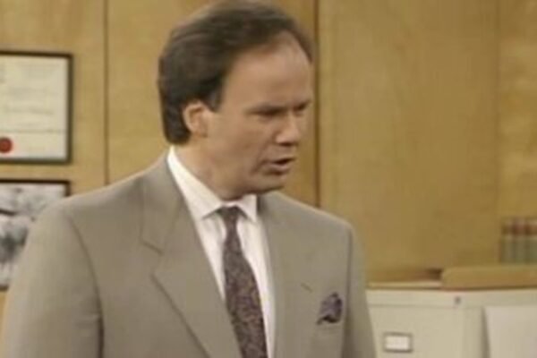 Dennis Haskins como el director Richard Belding en una oficina escolar