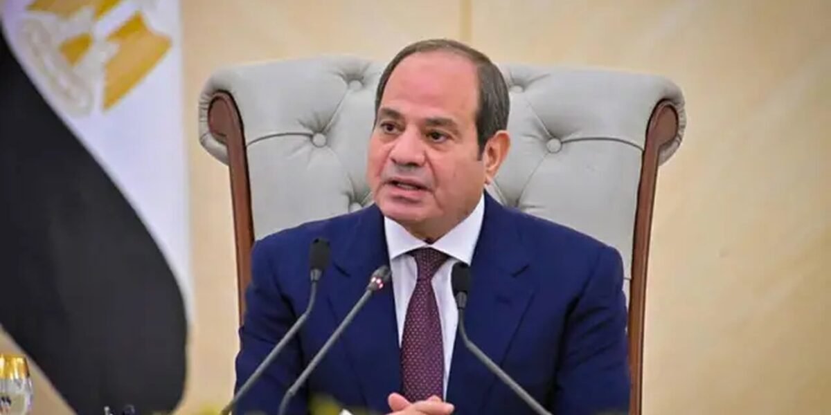 El presidente egipcio Abdelfatah al Sisi habla ante micrófonos, sentado en un sillón junto a la bandera de Egipto