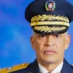 Abogados se querellan contra el jefe de la Policía por muertes en tiroteos Retrato oficial de Ernesto Rafael Rodríguez García con uniforme de gala y gorra de oficial, junto a la bandera dominicana.