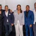 Cinco integrantes del equipo de la película «La esquina 'ta en candela» posan frente a la pantalla de una sala de cine durante su presentación