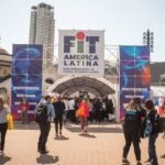 Visitantes entran por el acceso de la Feria Internacional de Turismo de América Latina (FIT) en una edición anterior, con carteles de bienvenida en varios idiomas