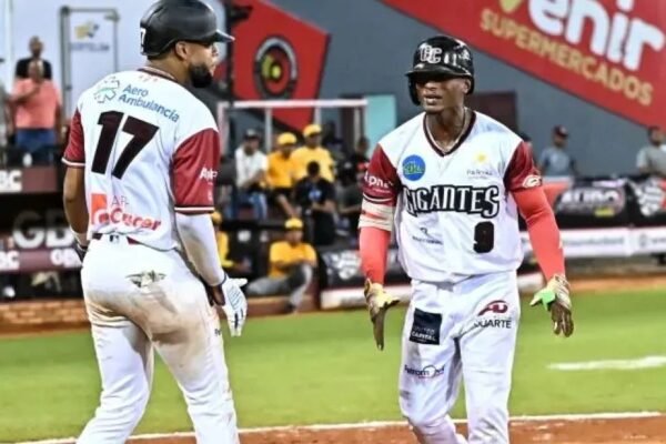 Dos jugadores de los Gigantes del Cibao se saludan en el home tras anotar carrera