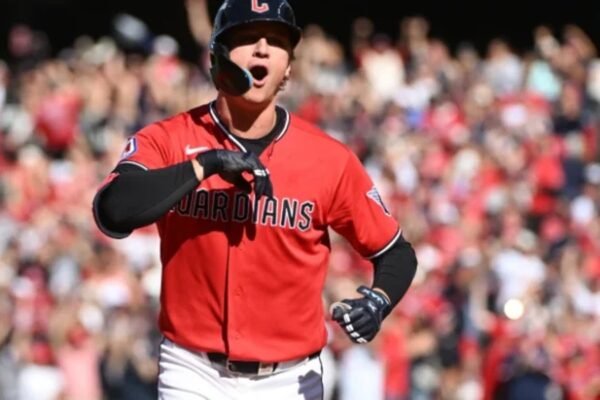 Un jugador de los Guardianes de Cleveland, con uniforme rojo, celebra mientras recorre las bases ante el público