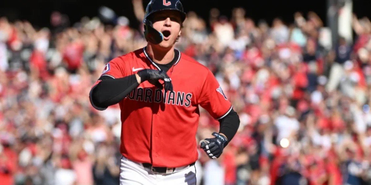 Un jugador de los Guardianes de Cleveland, con uniforme rojo, celebra mientras recorre las bases ante el público