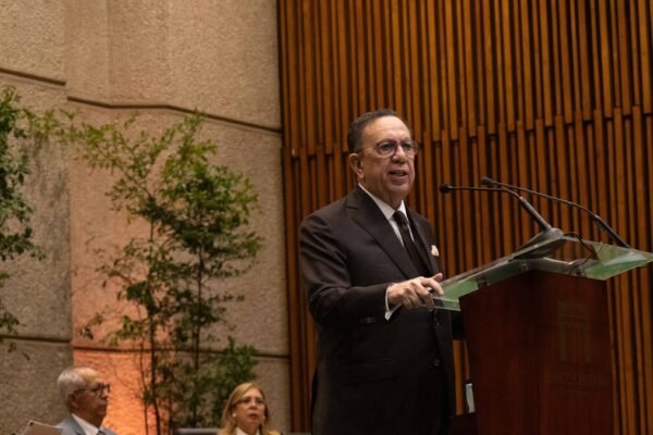 Héctor Valdez Albizu habla desde un atril del Banco Central ante un auditorio