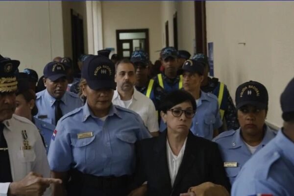 Agentes de la Policía Nacional escoltan a un hombre y a una mujer por un pasillo de un edificio judicial