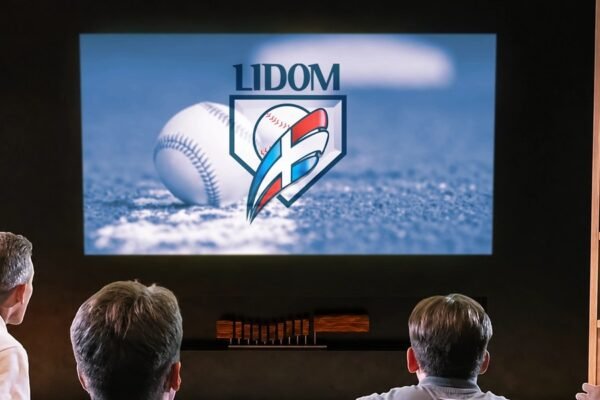 Aficionados de espaldas observan una pantalla con el logo de la Lidom y una pelota de béisbol