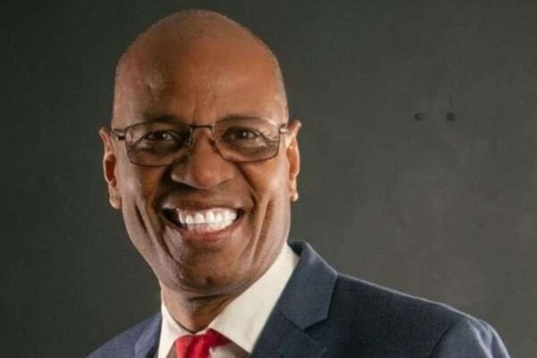 Luis Pérez, presidente del Colegio Dominicano de Periodistas, sonríe con gafas, saco azul y corbata roja
