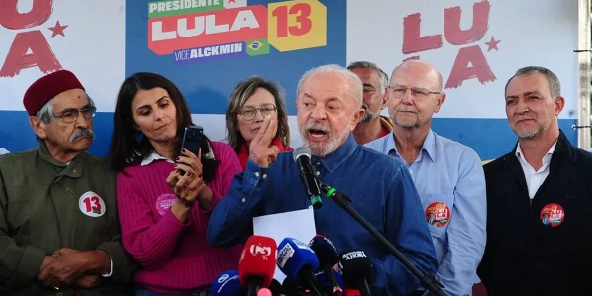 Luiz Inácio Lula da Silva habla ante varios micrófonos de medios en un acto de campaña, rodeado de simpatizantes y frente a carteles de su candidatura