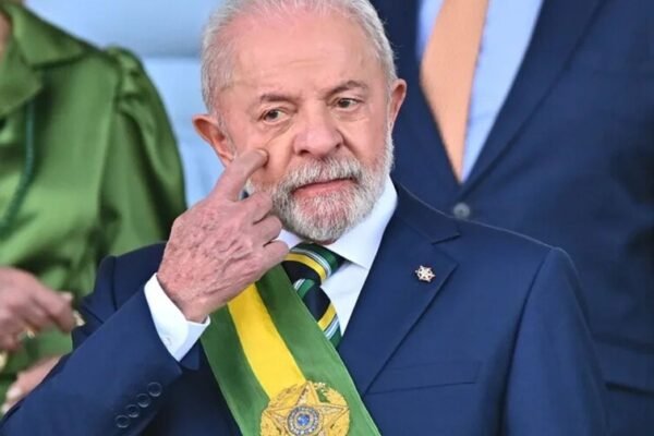 Lula da Silva con la banda presidencial de Brasil se toca el párpado con un dedo