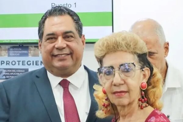 Entrega de documentos del Colegio Dominicano de Notarios a una notaria durante el acto de pensiones