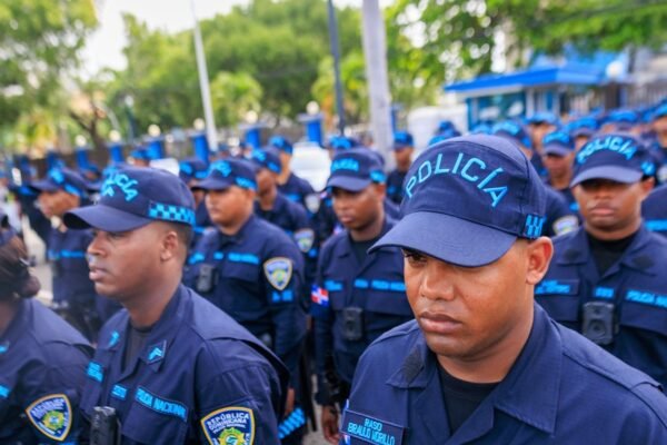 Agentes de la Policía Nacional con uniforme azul y gorras formados en fila.