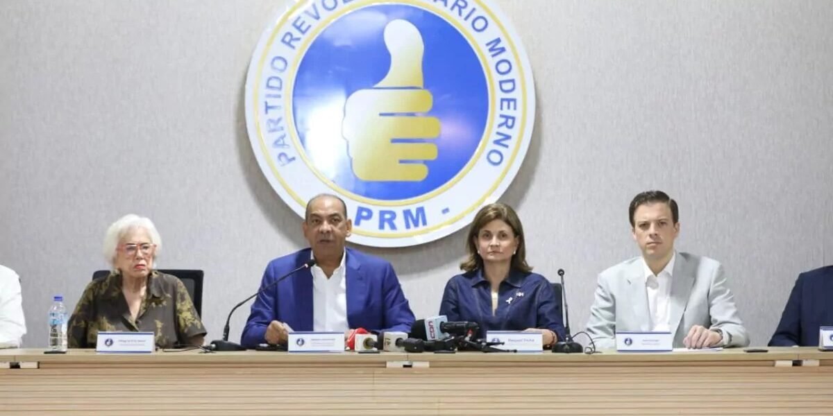 Cuatro dirigentes sentados en una mesa con micrófonos ofrecen una rueda de prensa bajo el logotipo del Partido Revolucionario Moderno.
