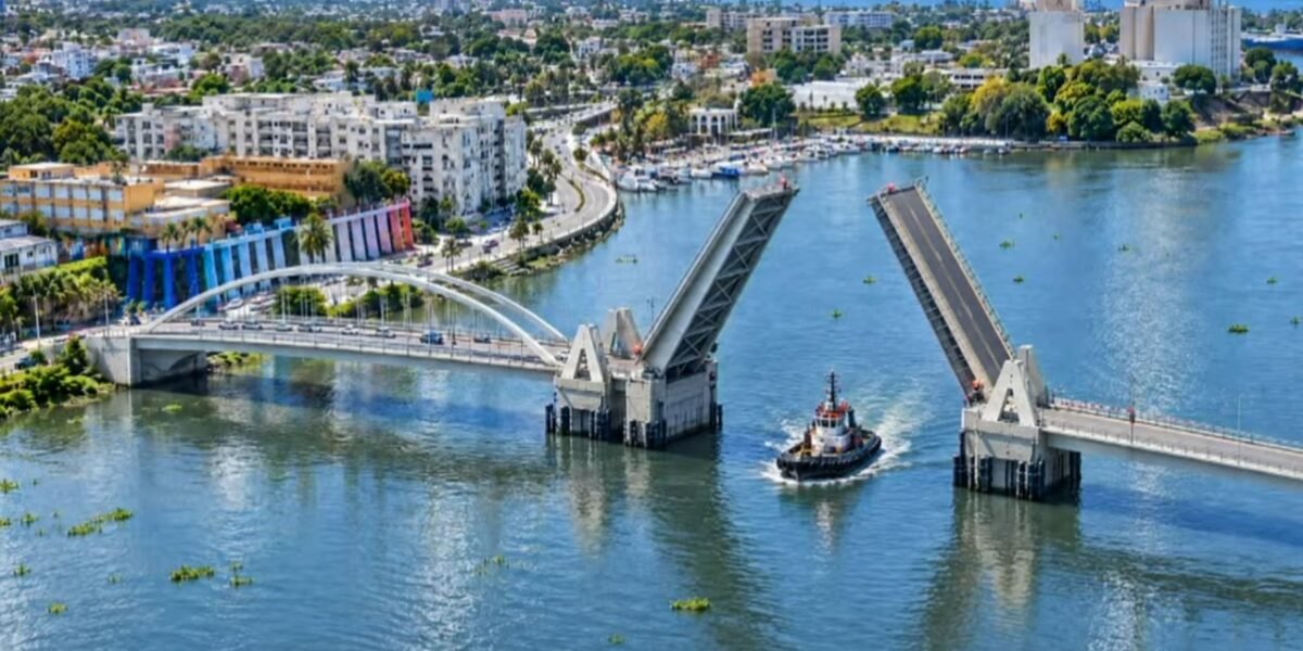 Representación del nuevo puente basculante sobre el río Ozama con sus dos tramos levantados para dar paso a un remolcador, con Santo Domingo al fondo