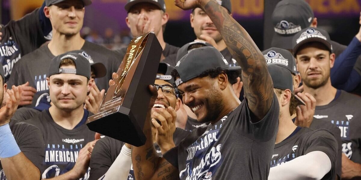 Jugadores de los Rays de Tampa Bay con gorras de la Serie Mundial celebran mientras uno de ellos alza el trofeo al Jugador Más Valioso de la Serie de Campeonato de la Liga Americana 2026