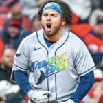 Un jugador de los Rays de Tampa Bay celebra con gritos en la base durante un juego de postemporada
