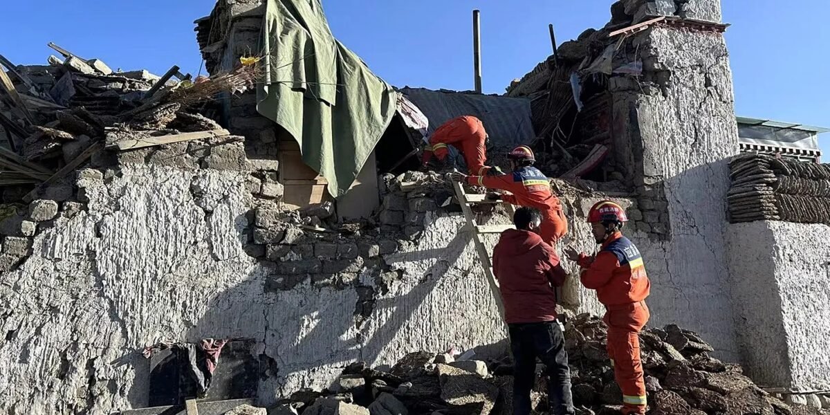 Bomberos con uniforme naranja trabajan sobre los escombros de una vivienda de piedra derrumbada, foto de archivo