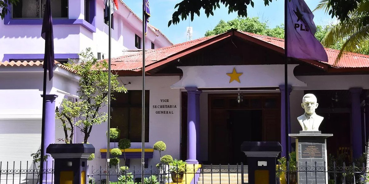 Fachada de la casa nacional del Partido de la Liberación Dominicana con banderas moradas