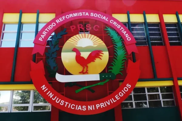 Emblema del Partido Reformista Social Cristiano, con un gallo rojo y el lema Ni injusticias ni privilegios, en una fachada roja