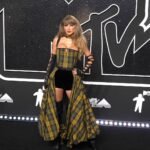 Taylor Swift posa con un vestido de cuadros amarillos y negros en la alfombra roja de los premios MTV VMA