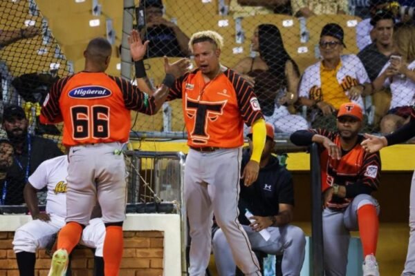 Jugadores de los Toros del Este chocan las manos frente al dugout durante un partido de la Lidom