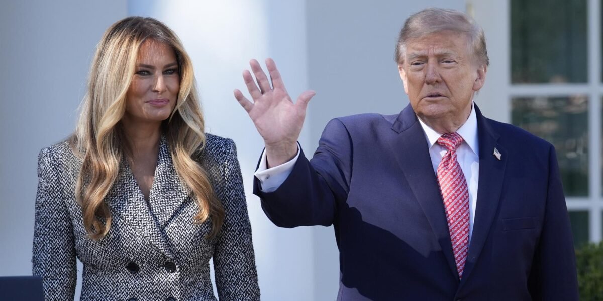 Donald Trump saluda con la mano junto a Melania Trump, al aire libre frente a un edificio de columnas blancas