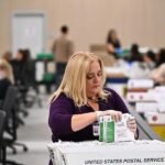 Trabajadores electorales procesan sobres de votos por correo en Estados Unidos