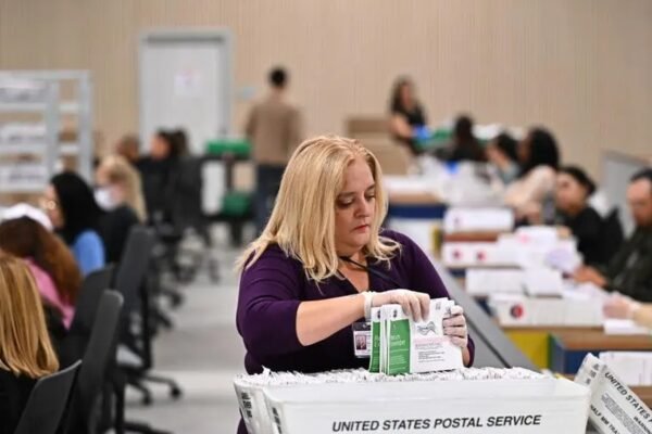 Trabajadores electorales procesan sobres de votos por correo en Estados Unidos