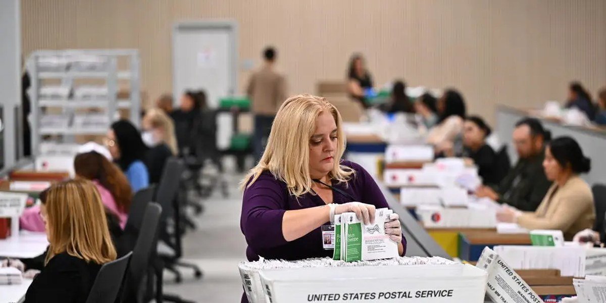 Trabajadores electorales procesan sobres de votos por correo en Estados Unidos