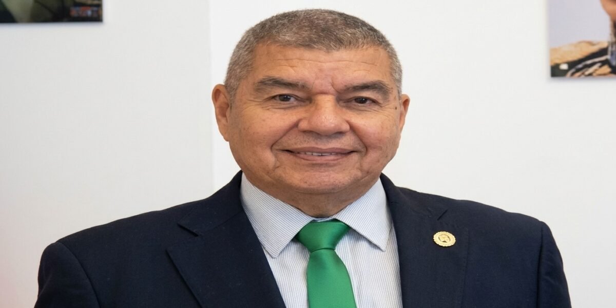 Wilmer Barrientos, de traje oscuro y corbata verde, sonríe en una sala de paredes blancas