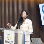 La procuradora general Yeni Berenice Reynoso habla en un podio de Finjus, con la pantalla del Ministerio Público al fondo