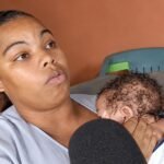 SNS investiga denuncia de madre sobre un gemelo; la Maternidad lo niega Yeraldin de la Paz habla ante un micrófono mientras sostiene a su bebé